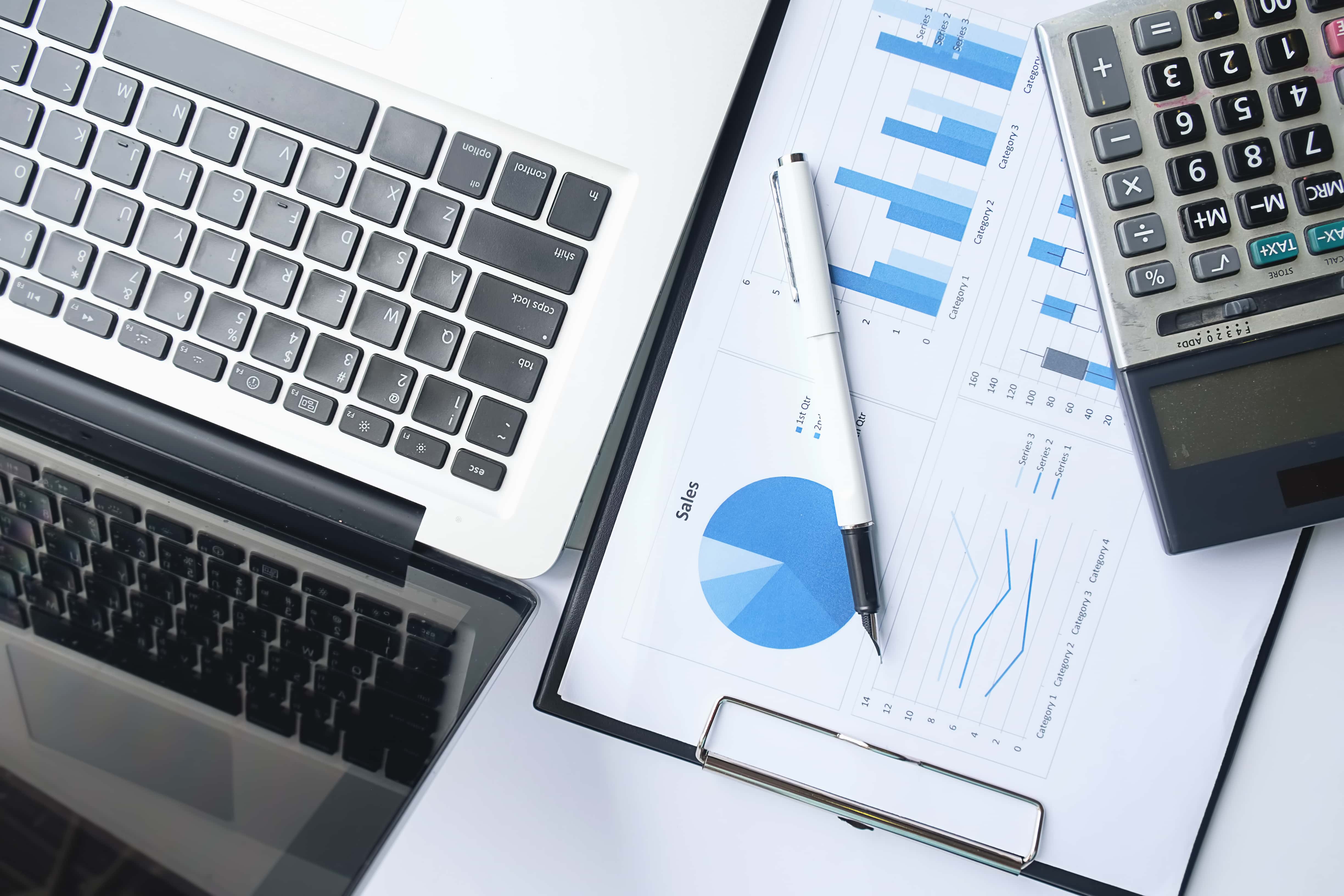 Notebook exibindo gráficos financeiros em uma mesa corporativa